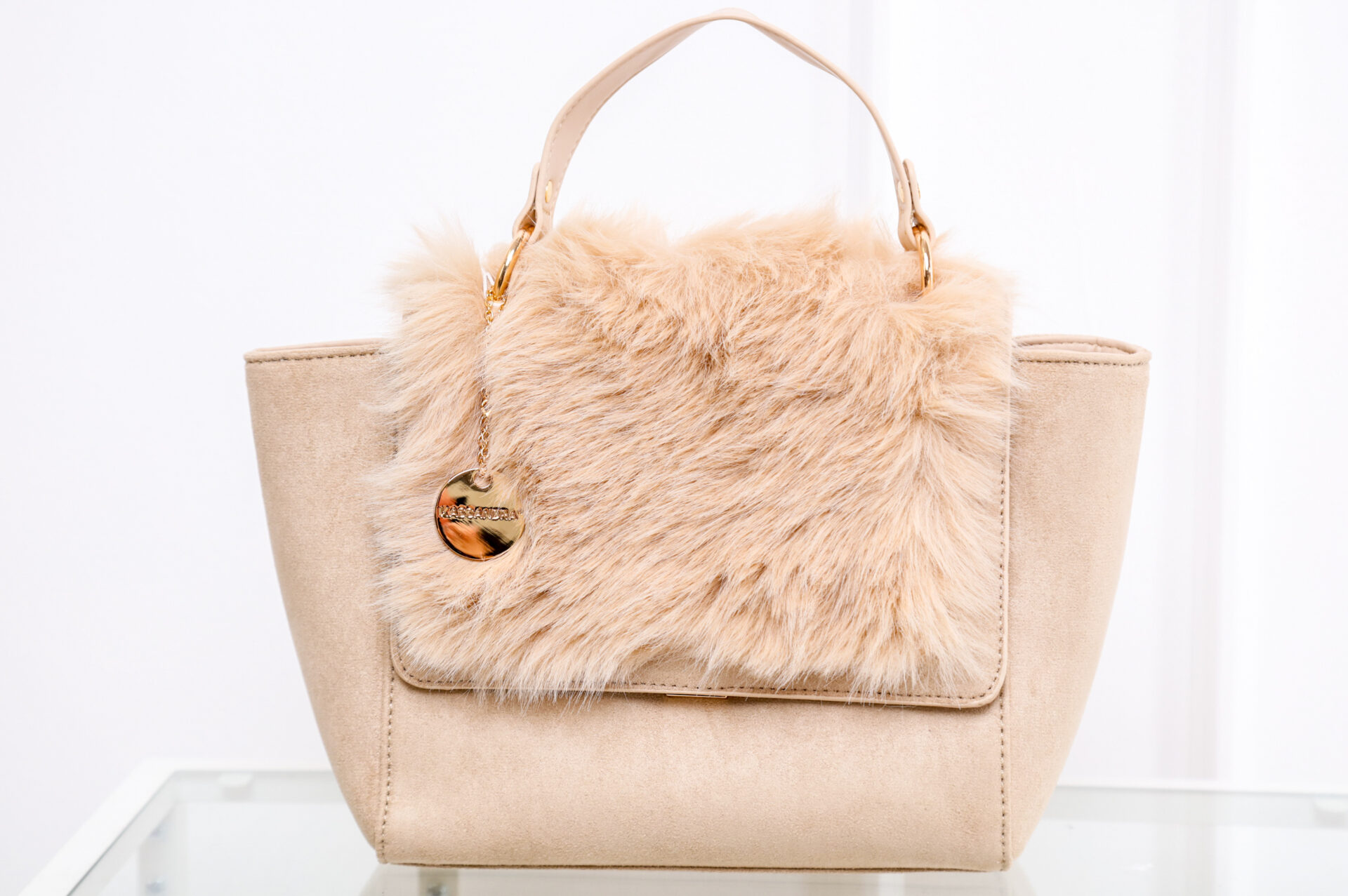 A bézs színű, egyedi CASSY elegáns szőrmés női kézi táska a műszőrme díszítésének köszönhetően a nőiesség és a kifinomult megjelenés tökéletes elegye.