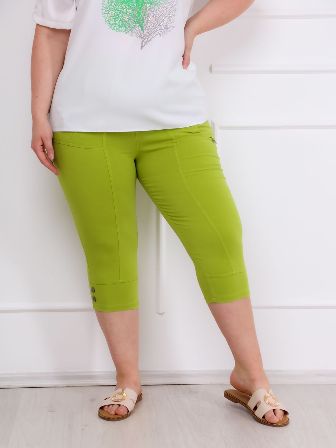 A lime zöld színű, divatos ANA elegáns PLUS SIZE női caprinadrág frissességet és eleganciát hoz a megjelenésedbe – tökéletes választás a melegebb napokra.