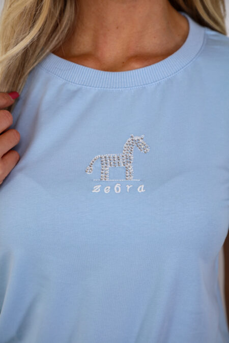 A kék színű ZEBRA pamut nyári női felső kényelmes, puha tapintású pamut felső hímzett és strasszos zebradísszel – tökéletes választás stílusos nyári napokra.